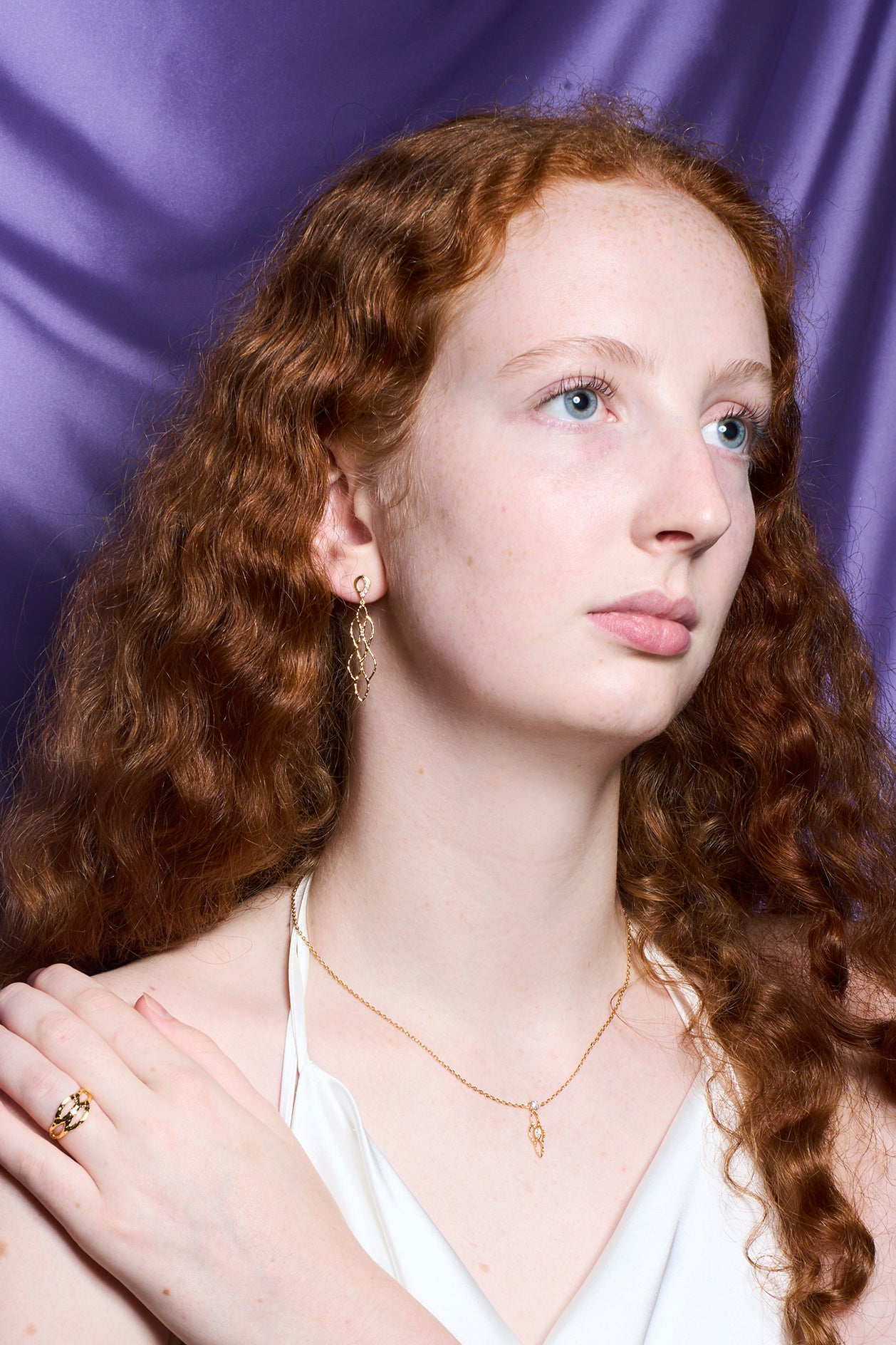 Model wearing Siren necklace against soft lighting, showcasing how the gold vermeil and moissanite catch the light with elegant styling